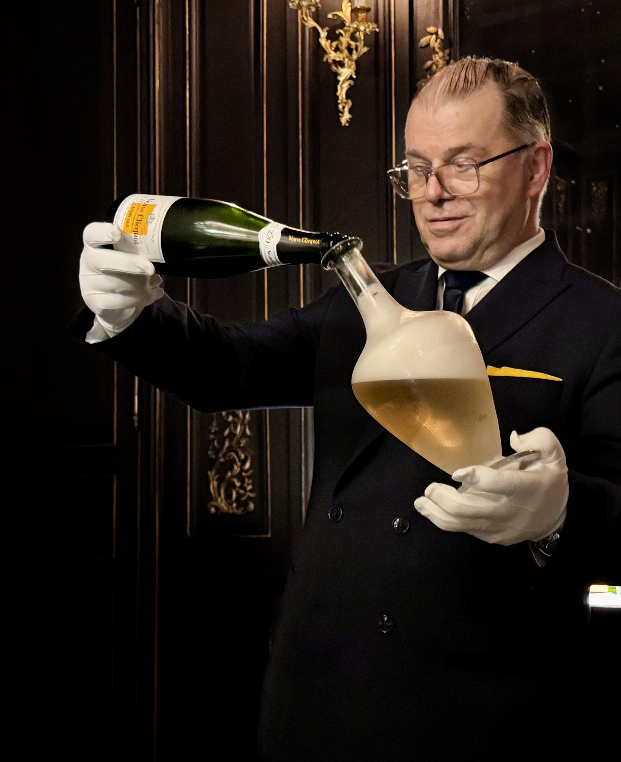 A sommelier pouring Champagne into a decanter